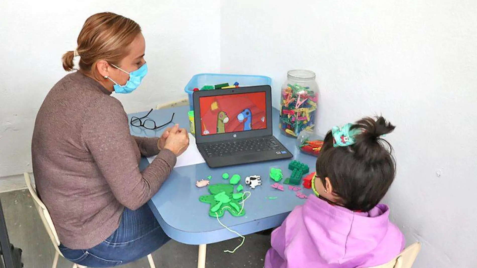 mujer y niña sentadas a la mesa